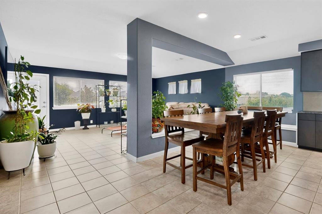Open-concept living space featuring tile flooring, recessed lighting, and multiple windows with blinds Open-concept living space featuring tile flooring, recessed lighting, and multiple windows with blinds