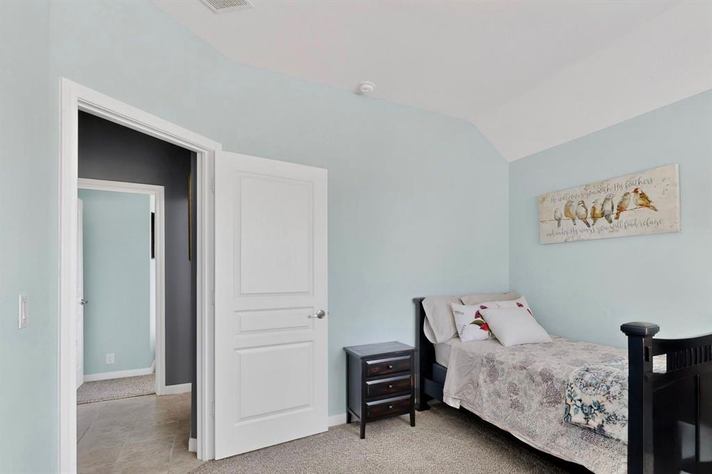 Bedroom featuring a vaulted ceiling and light blue walls