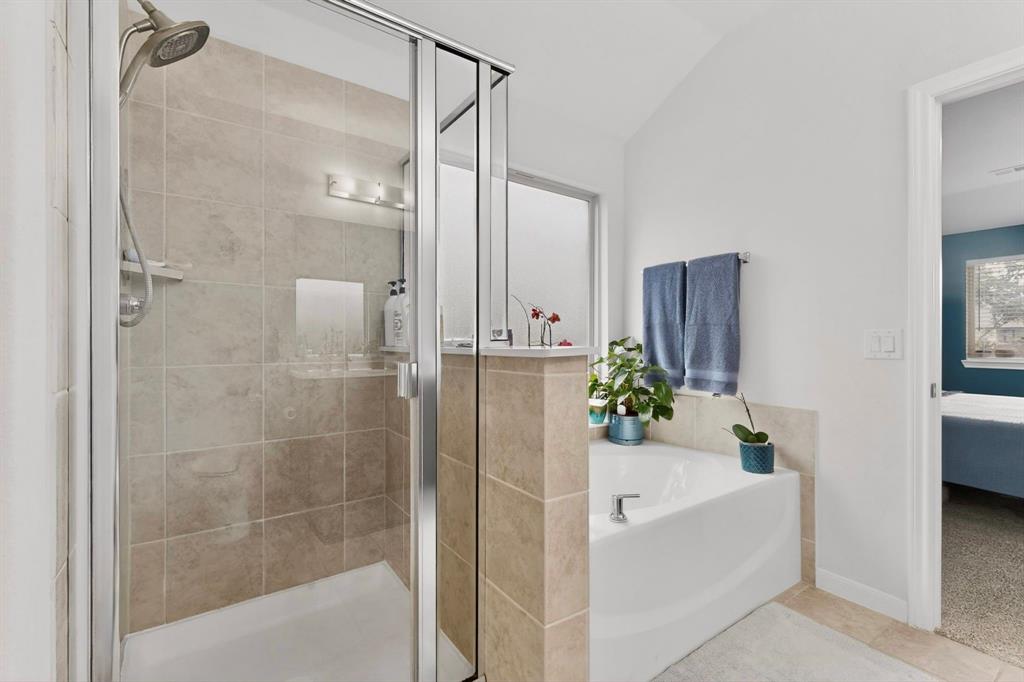 Tiled walk-in shower with clear glass enclosure and built-in niche