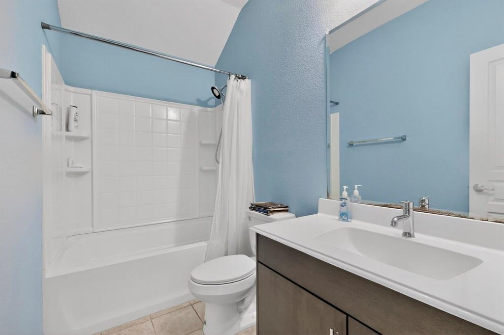 Bathroom with a single vanity featuring an integrated white sink, chrome faucet, and dark wood-finish cabinetry