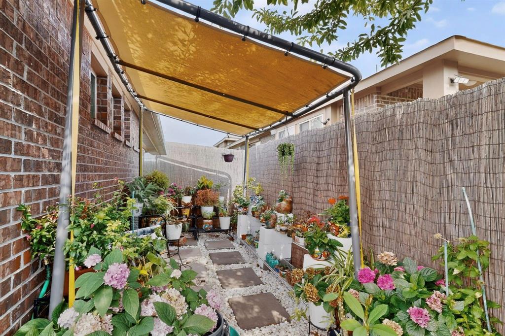 Covered side yard featuring a brick facade, privacy screening, stone step pathway, gravel ground cover, and overhead shade structure Covered side yard featuring a brick facade, privacy screening, stone step pathway, gravel ground cover, and overhead shade structure