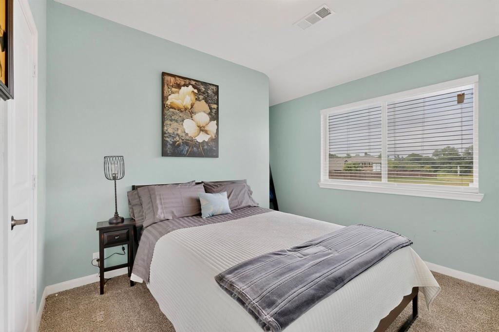 Carpeted room featuring light blue walls, white trim, and a large window with white blinds