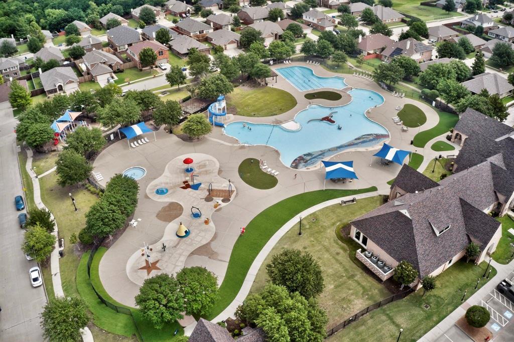 Community amenities featuring a large resort-style pool with a water slide, a separate splash pad, multiple shaded lounge areas, and surrounding green spaces