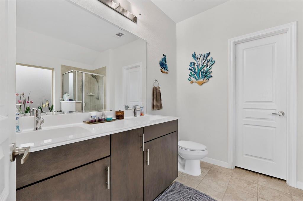 Dual vanity with integrated sinks, contemporary dark wood-finish cabinetry, brushed nickel hardware, and a large mirror