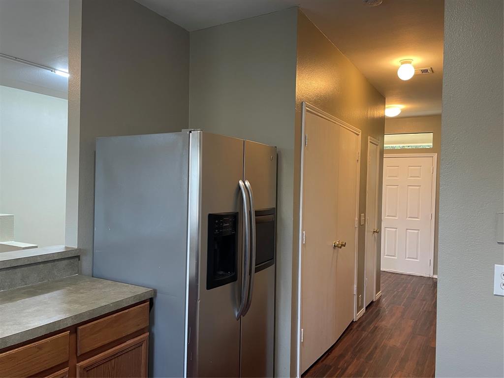Hallway with wood-finish flooring, flush mount lighting, and multiple panel doors