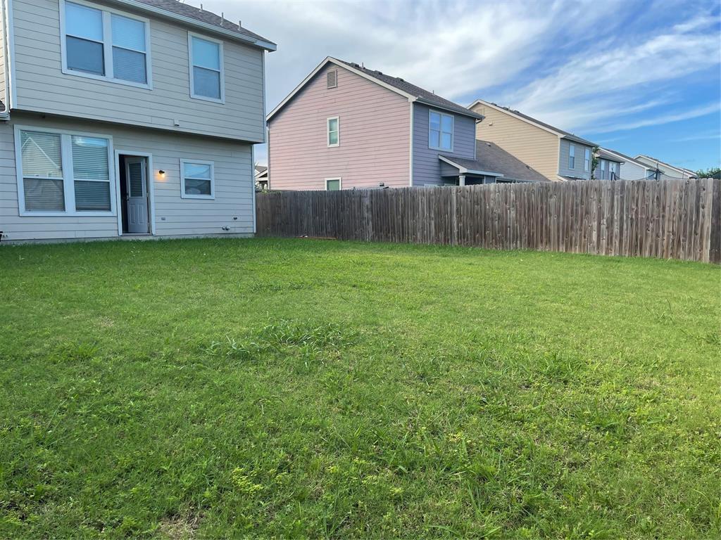Expansive grass backyard with a wood privacy fence
