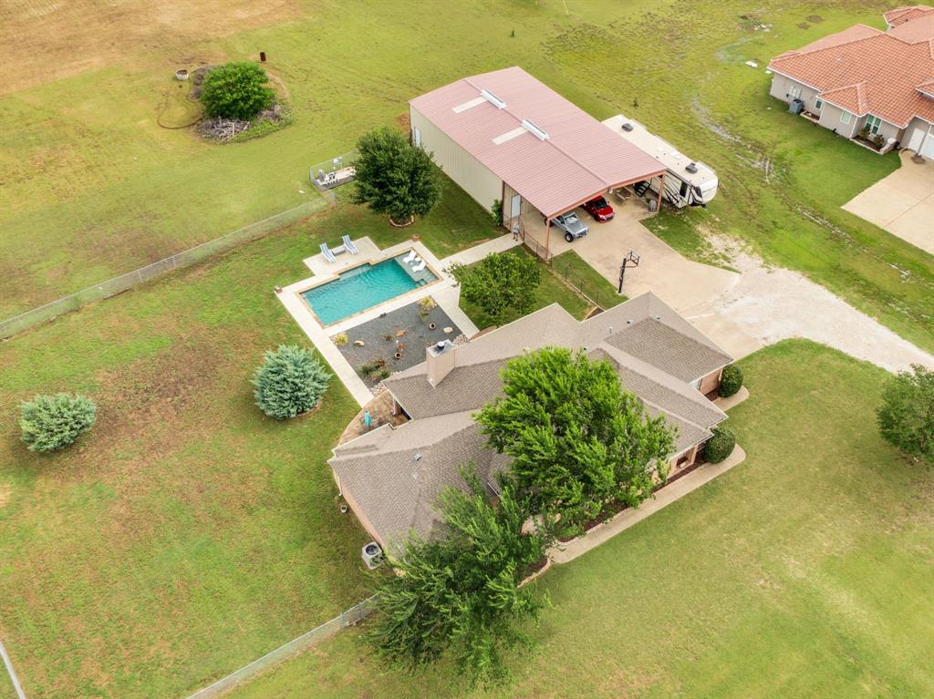 Aerial property view featuring a rectangular swimming pool with surrounding patio space