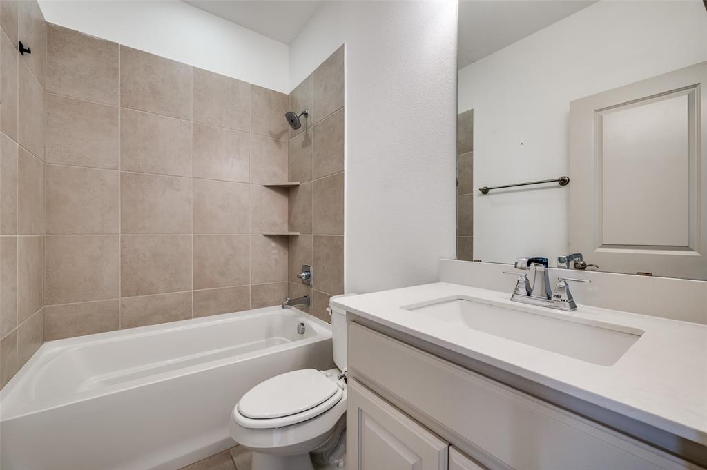 Full bathroom with vanity, shower tub combination, neutral tile surround, and simple clean design, serving secondary bedrooms and adding everyday functionality for residents searching for a McKinney TX townhome with multiple full bathrooms in a Collin County suburban neighborhood