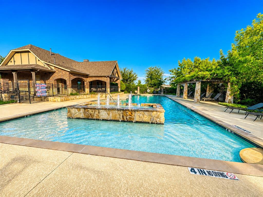 Resort-style pool with a stone fountain feature and an expansive deck