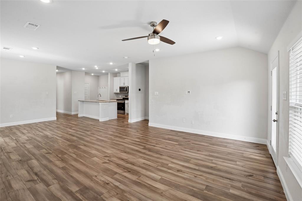 Open-concept living area featuring wood-finish flooring, recessed lighting, and a ceiling fan