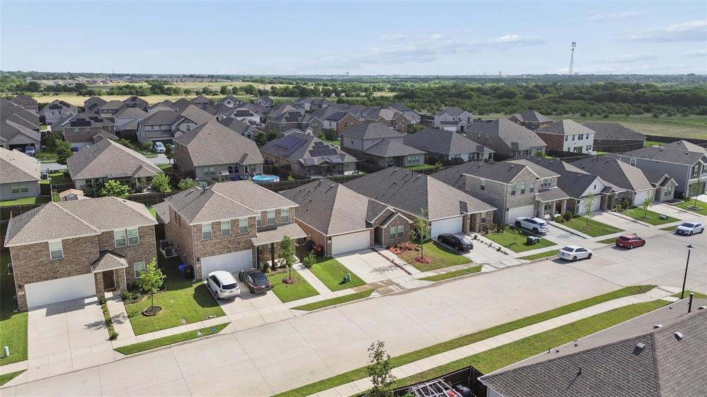 Residential neighborhood featuring a consistent architectural style, brick and siding exteriors, attached garages, and paved driveways