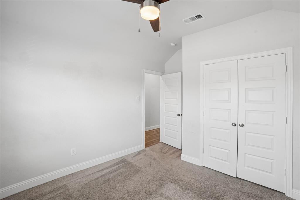 Bedroom featuring neutral carpeting, white trim, a ceiling fan with integrated lighting, and a closet with bifold panel doors