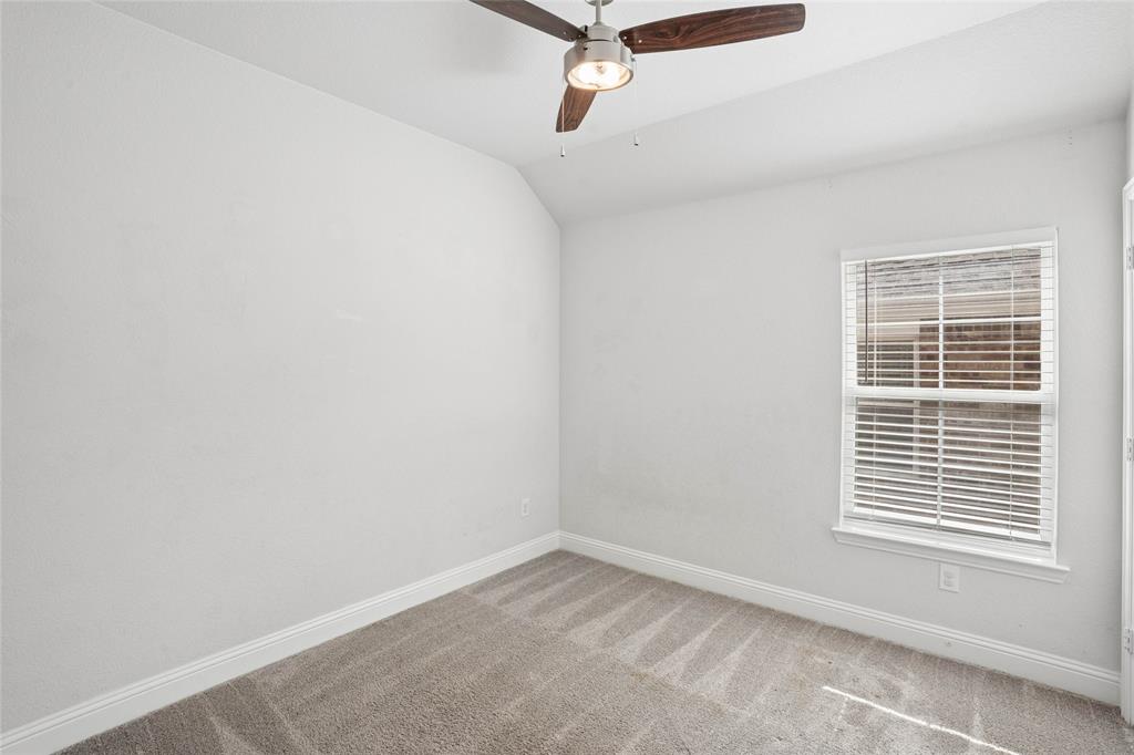 Neutral wall paint, plush carpet flooring, and a ceiling fan with integrated lighting