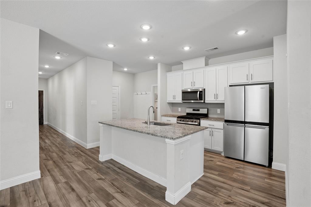 Kitchen with white shaker cabinetry, stainless steel appliances, and granite countertops