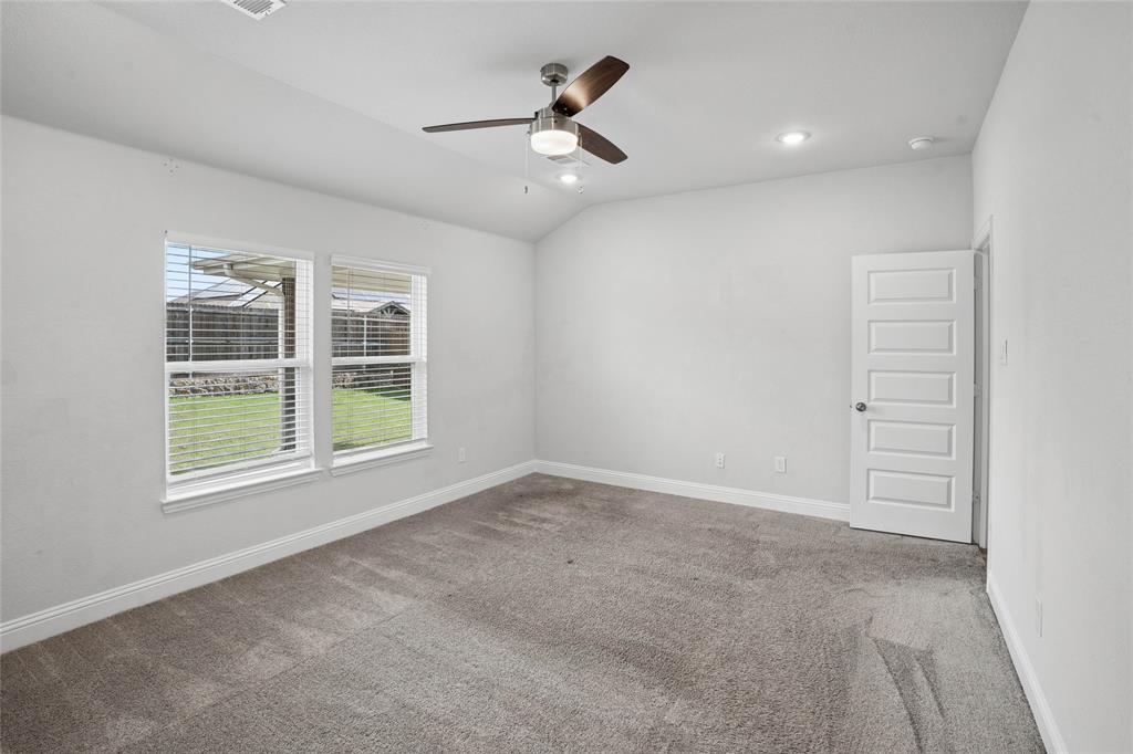 Carpeted room featuring dual windows with blinds, a five-panel interior door, a ceiling fan with integrated lighting, and recessed ceiling lights