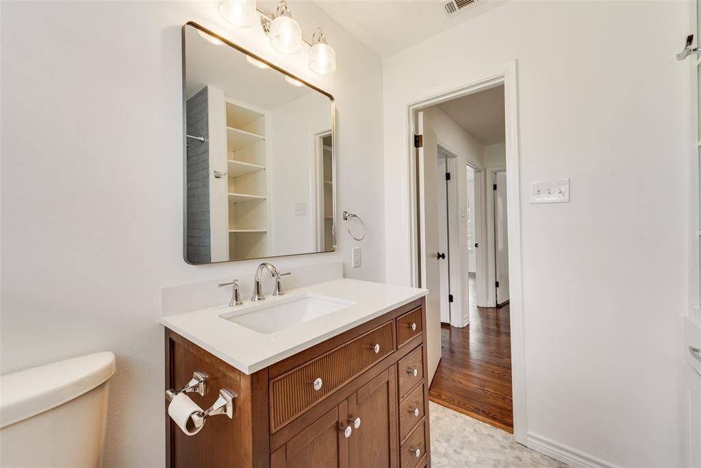 Bathroom vanity with a white countertop, undermount sink, and chrome fixtures