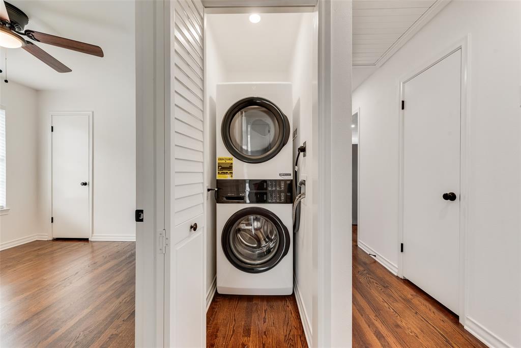 Dedicated laundry closet featuring a stacked washer and dryer unit, white louvered bifold doors, and a recessed ceiling light