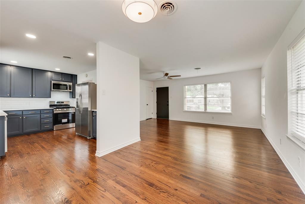 Open-concept living area and kitchen featuring wood-finish flooring