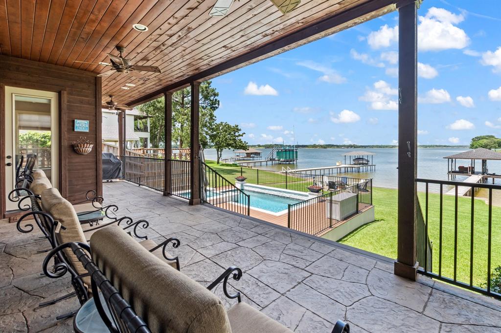 Elevated covered patio overlooking the pool, backyard, and open-water views.