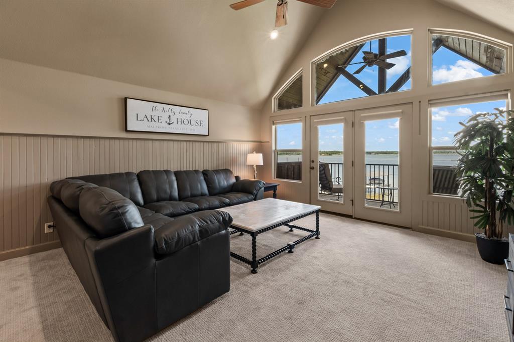 Upstairs Second Living Area with vaulted ceilings and open water views opening to the balcony.
