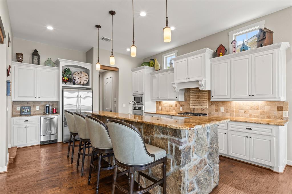Ample storage and bar seating at the stone accented island.