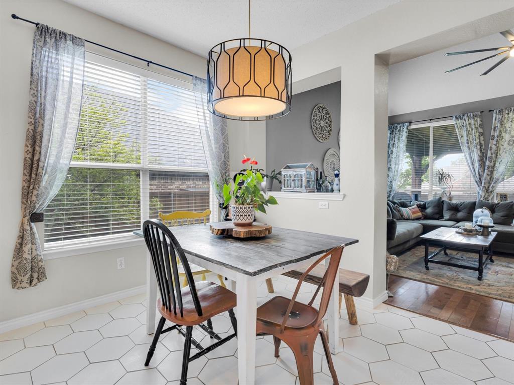 Dining area featuring white hexagonal tile flooring and a decorative overhead light fixture