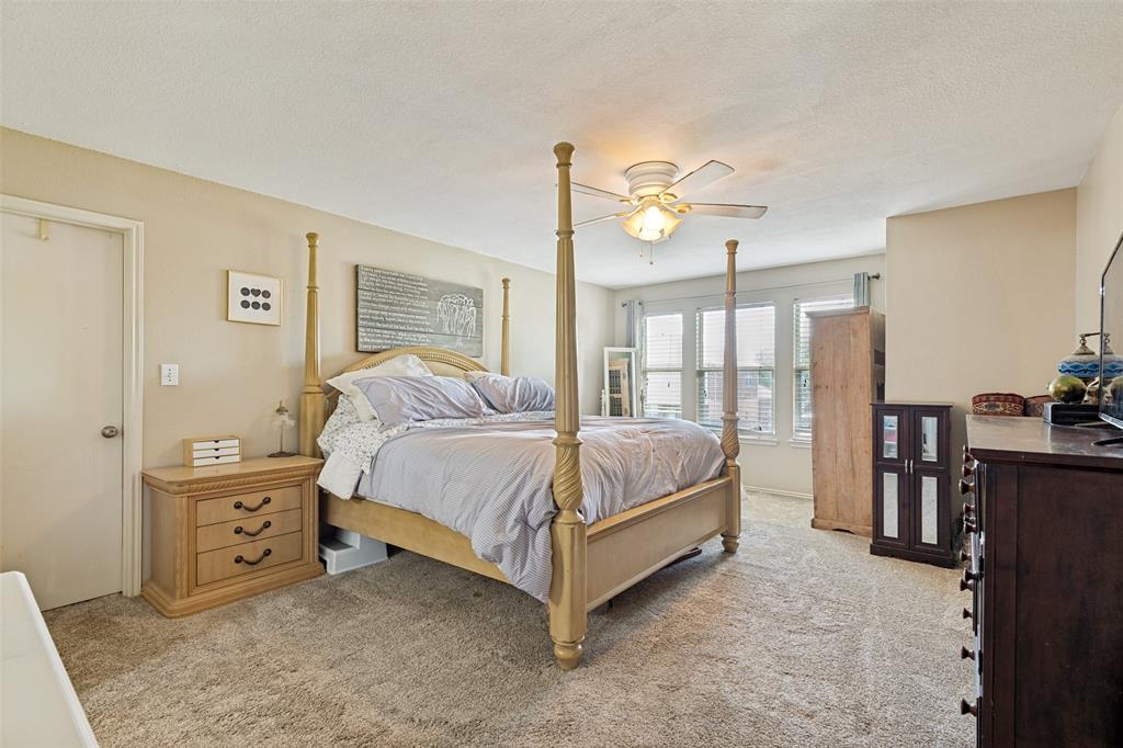 Carpeted room featuring a ceiling fan with integrated lighting, multiple windows with blinds, and light-toned walls
