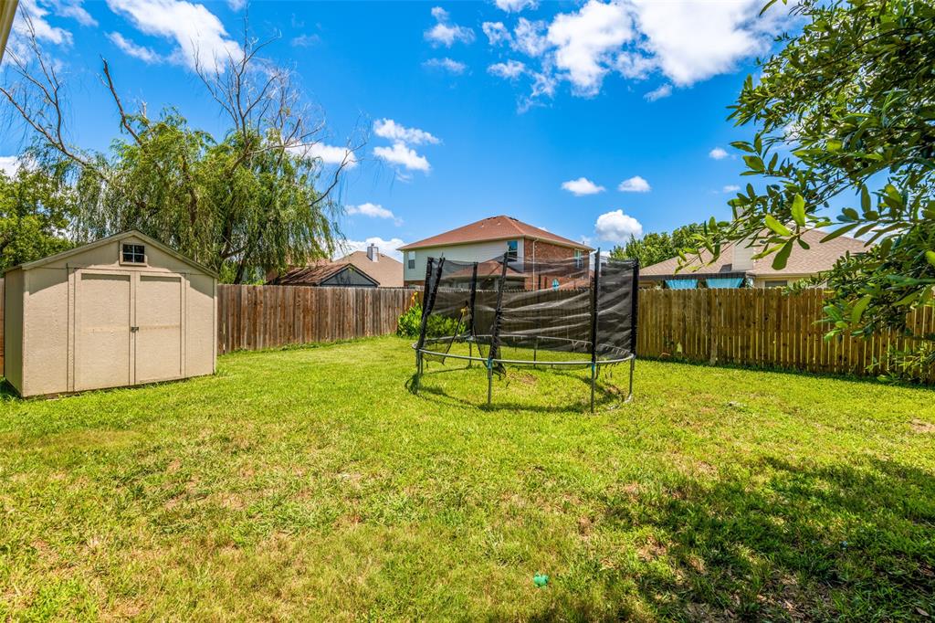 Expansive backyard featuring a manicured lawn, a detached storage shed, and a privacy fence