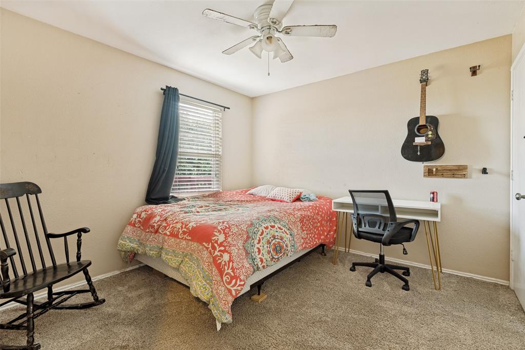 Carpeted interior room featuring a ceiling fan, a window with blinds, and light-toned walls