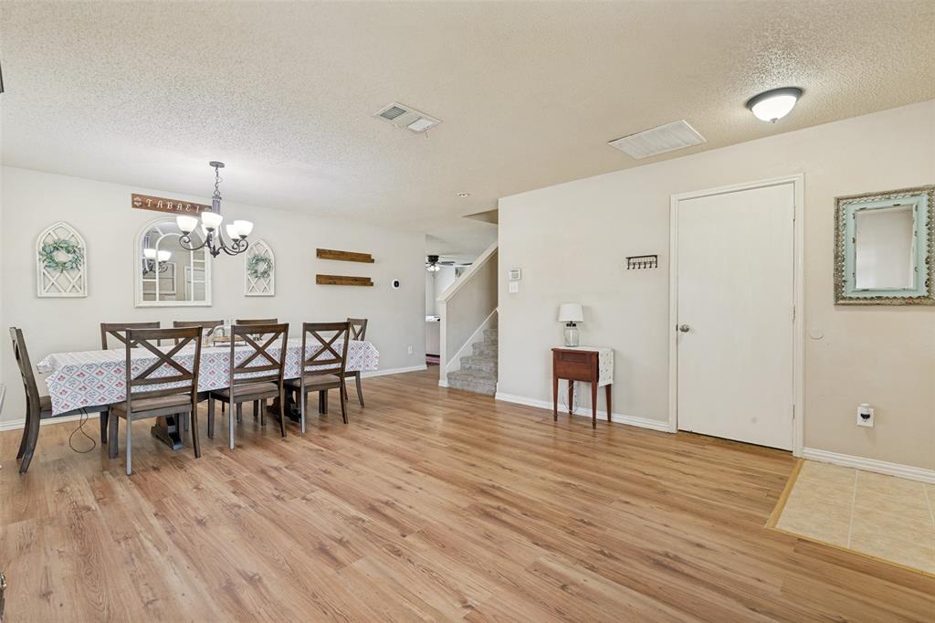 Spacious dining area featuring wood-finish flooring, a contemporary chandelier, and ample wall space