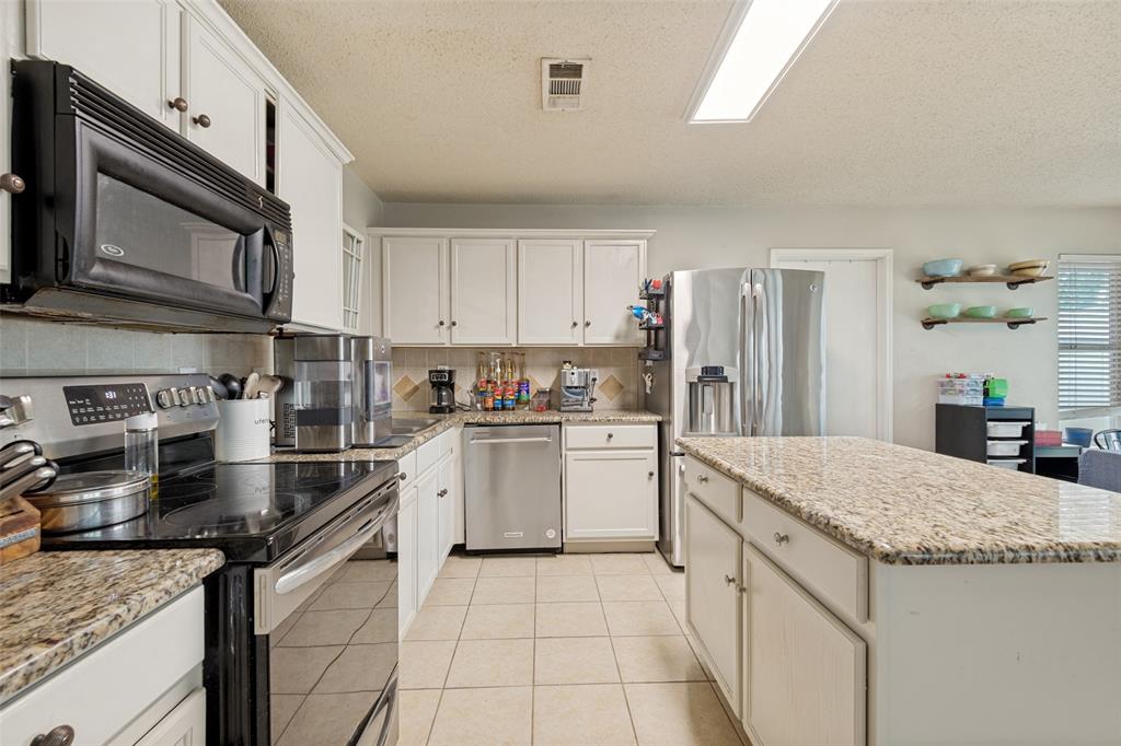 Kitchen featuring an expansive center island with a light granite-finish countertop