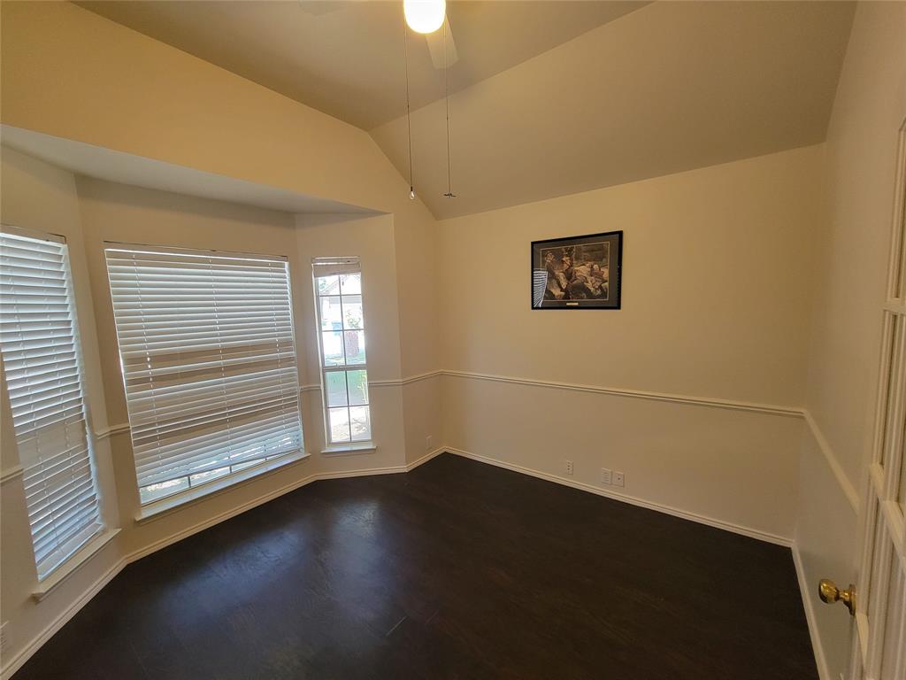 Office with bay window, glass door, and dark wood-style floors, ceiling fan, and lofted ceiling
