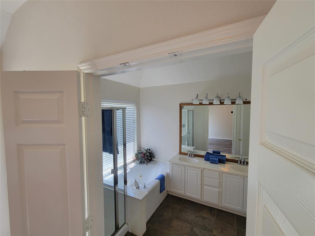 Bathroom featuring tile patterned flooring, separate shower and tub, and double vanity
