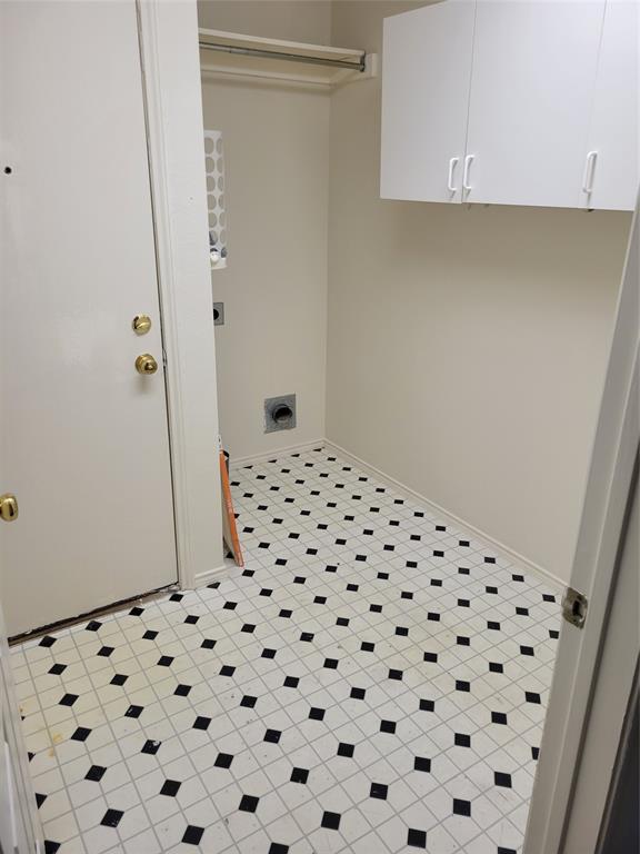 Washroom with cabinets, light tile patterned flooring, and electric dryer hookup