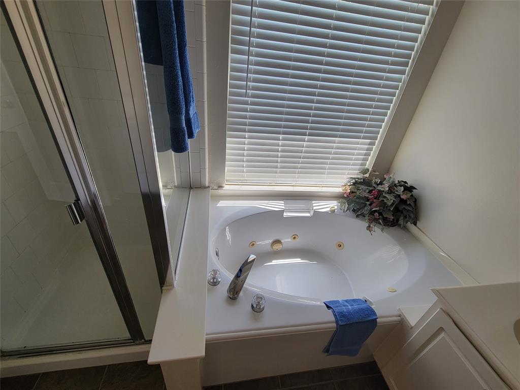 Bathroom featuring tile patterned flooring, separate shower and tub, and double vanity