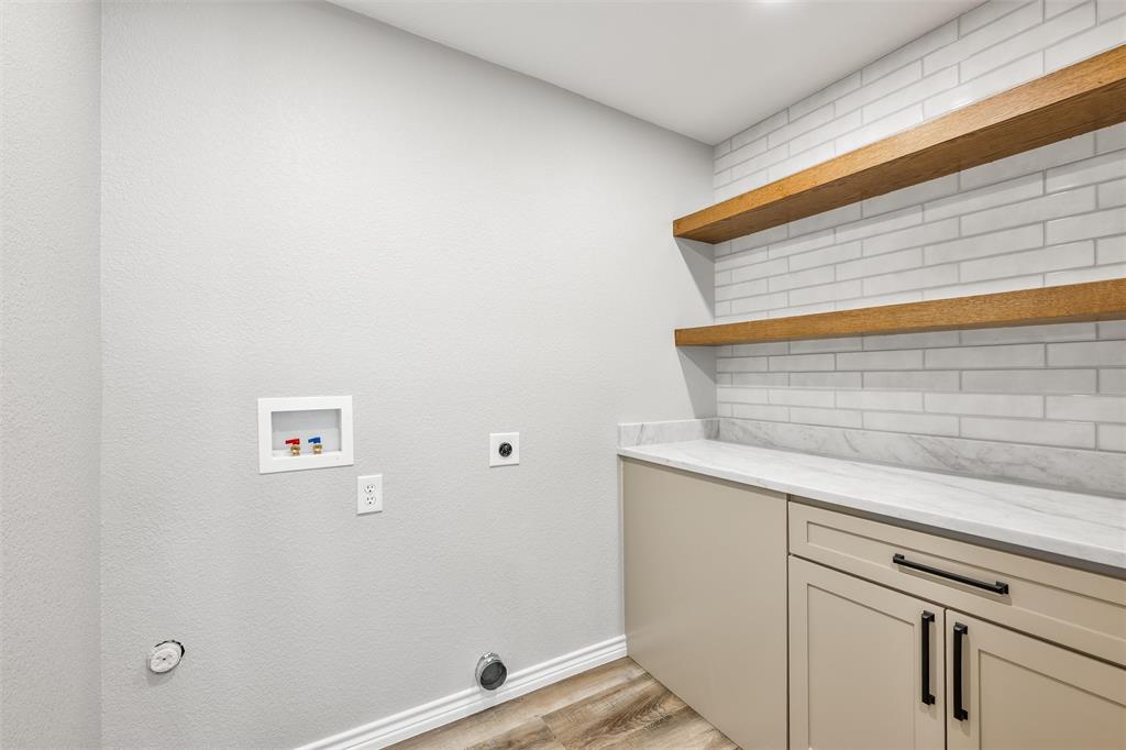 Custom laundry room with cabinets, quartz c-tops and shelves