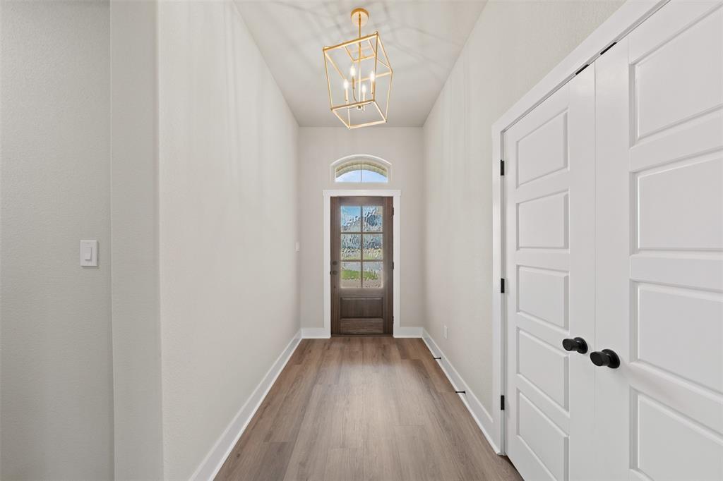 Entryway with wood-finish flooring, white baseboards, and light neutral wall finishes