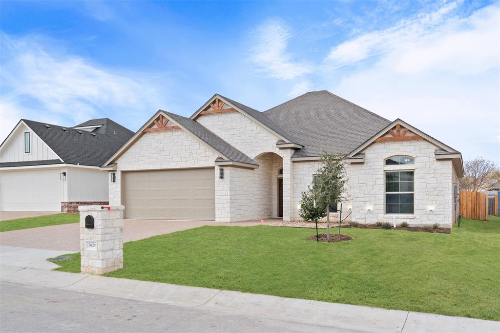 Stone exterior featuring a two-car garage, arched entry, and gabled rooflines with exposed wood accents Stone exterior featuring a two-car garage, arched entry, and gabled rooflines with exposed wood accents