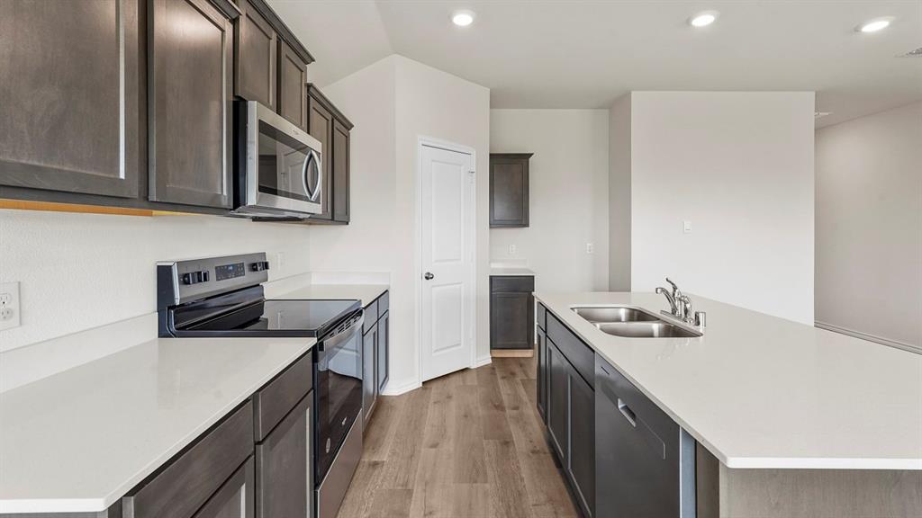 Modern kitchen featuring dark wood-finish cabinetry and light countertops