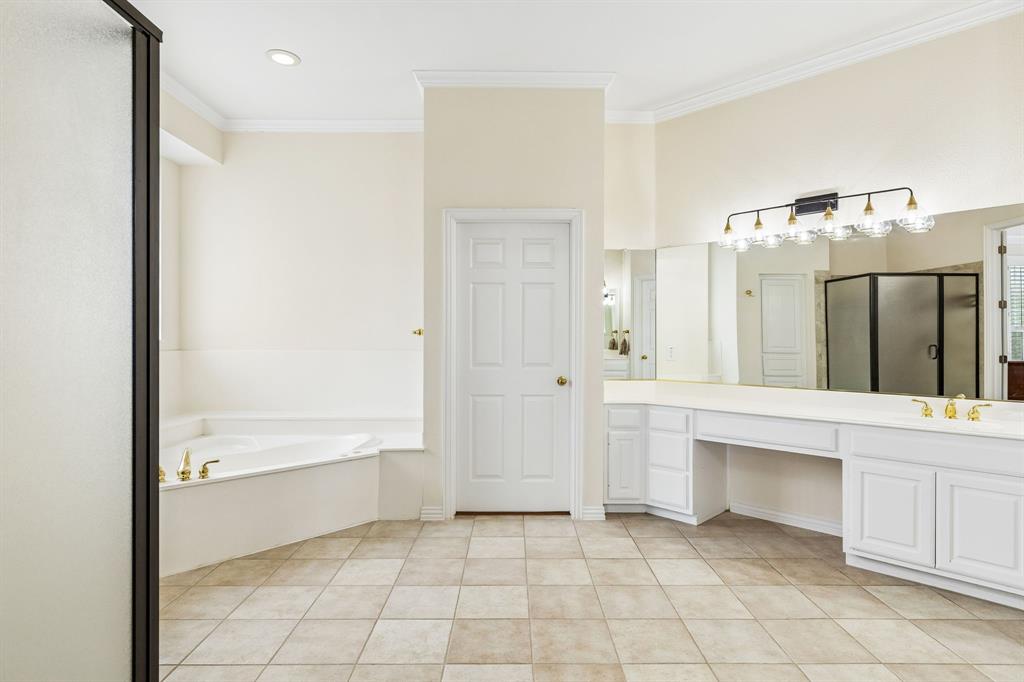 Primary ensuite offers separate vanities, his-and her closets, glass enclosed shower as well as plentiful storage.