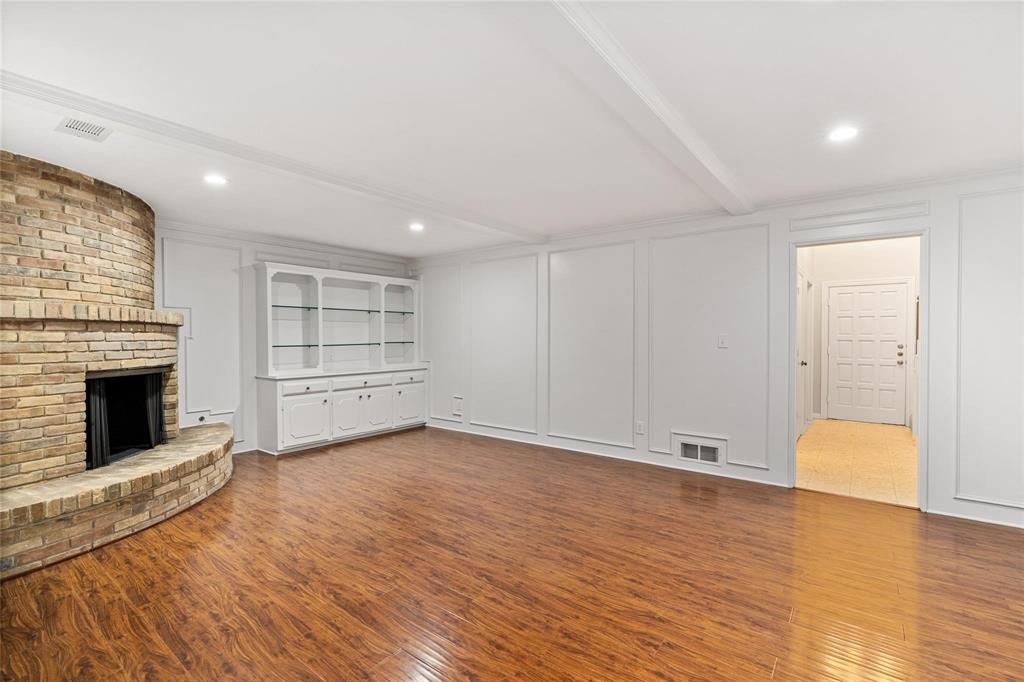 Large living room with built-in storage, gleaming floors and neutral paint.
