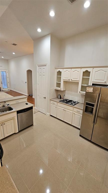 Kitchen featuring light-toned tile flooring, recessed lighting, white cabinetry, a built-in gas cooktop, and stainless steel appliances