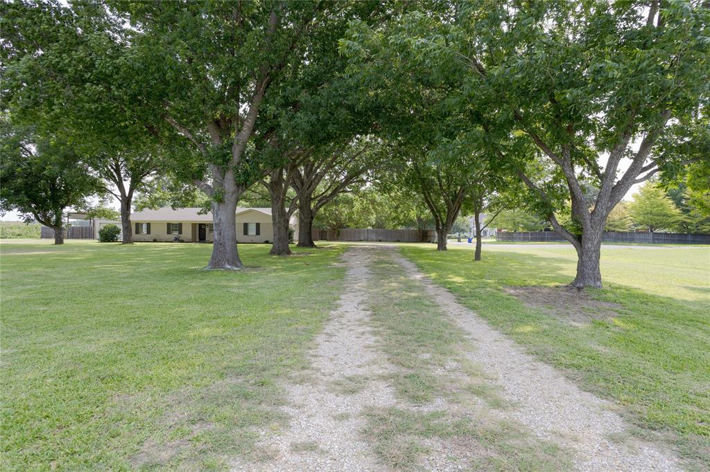 Beautiful tree lined driveway.This home features two driveways, one to the attached garage and another to the shop and covered RV parking.
