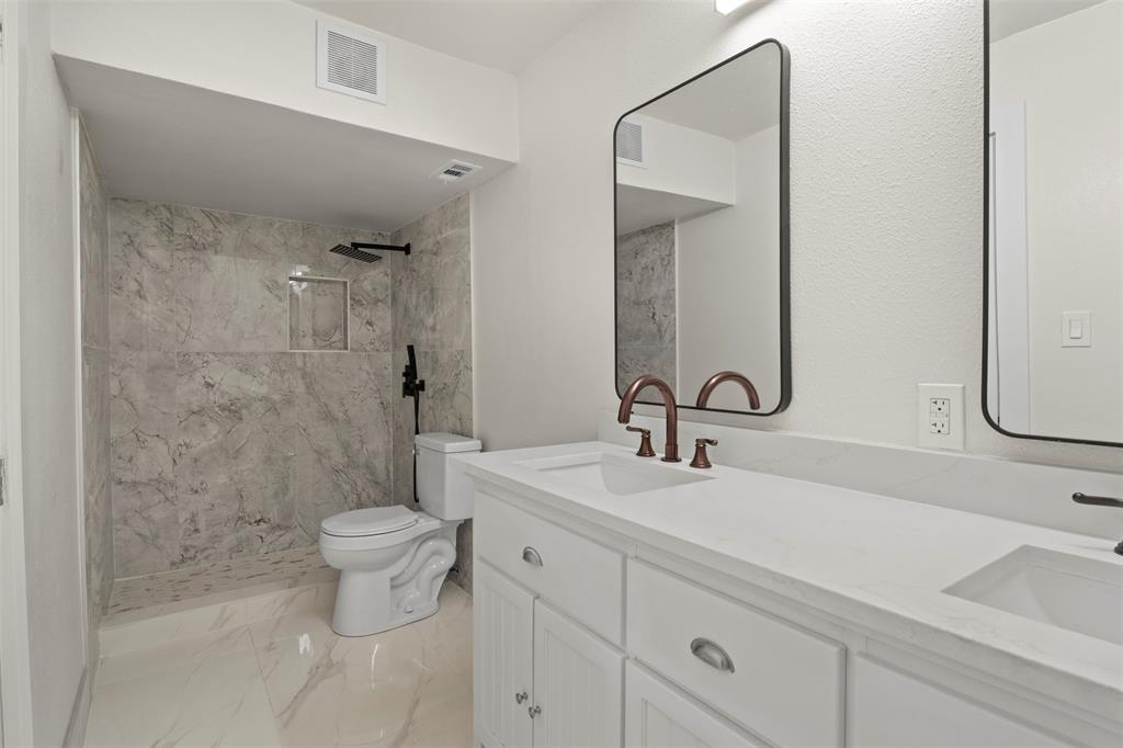 Contemporary bathroom featuring a spacious walk-in shower with marble-finish tile, a built-in shower niche, and matte black fixtures Contemporary bathroom featuring a spacious walk-in shower with marble-finish tile, a built-in shower niche, and matte black fixtures