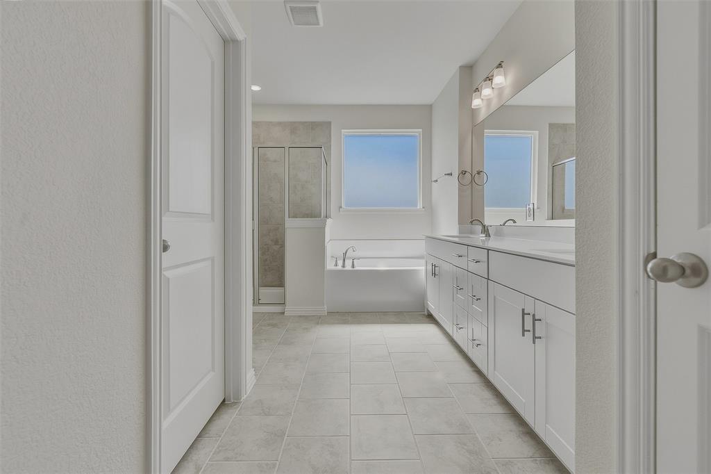Dual vanity with white cabinetry, integrated sinks, and a wide mirror