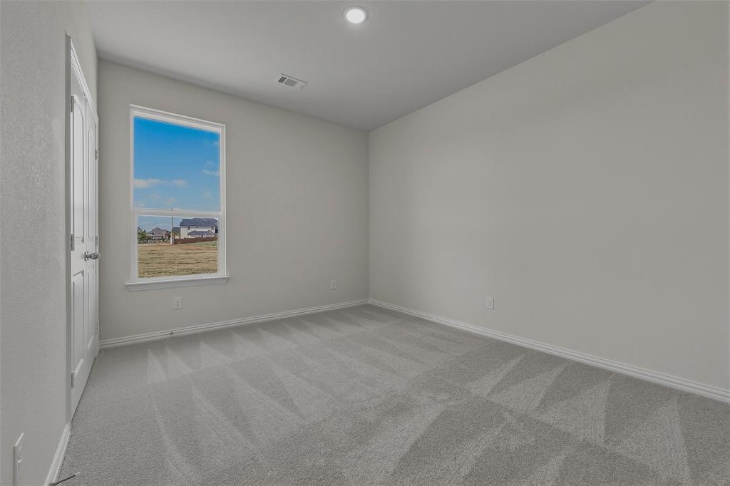 Neutral wall paint, gray carpeting, and a window with a white frame