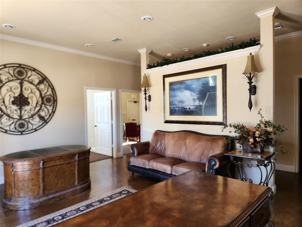 Recessed lighting illuminates a spacious room featuring crown molding and wood-finish flooring