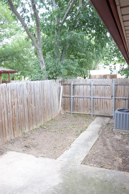 Private outdoor space featuring a wood fence, concrete patio, and garden area