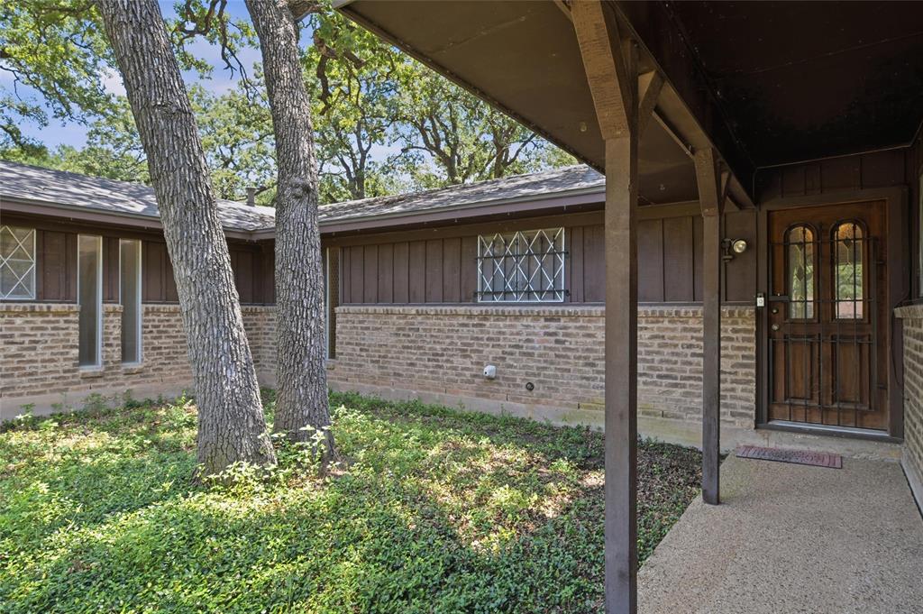 Covered entryway with a decorative wood and glass paneled door