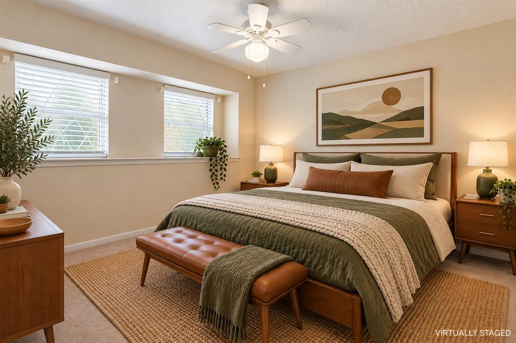Two windows with blinds, ceiling fan with light fixture, and carpet flooring